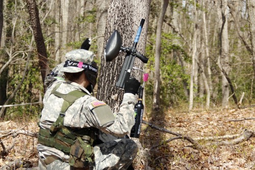 A cadet, armed with a paintball gun, keeps a look out for “enemy” forces.